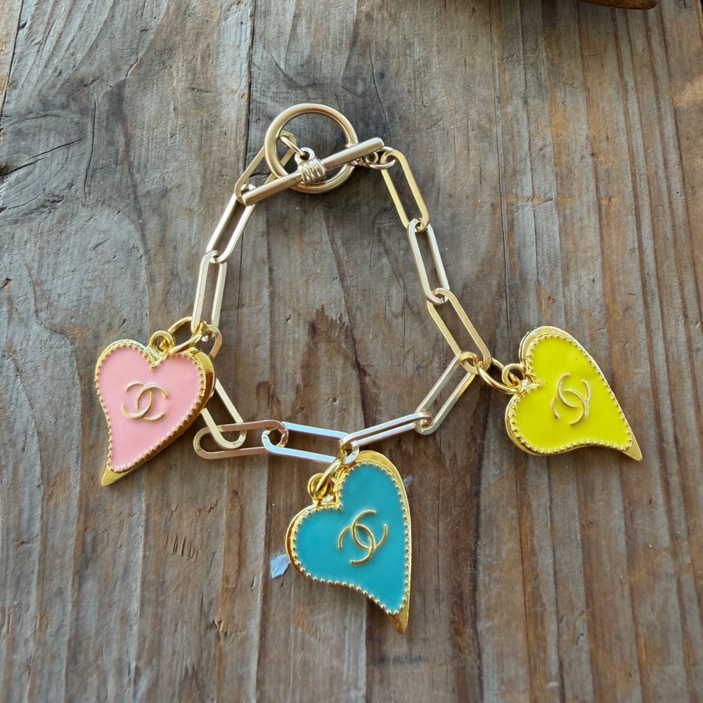 Luxury enameled hearts on a gold tone paper clip bracelet 7 inches.